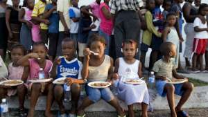 Дети едят пищу, розданную им в рамках гуманитарной операции на Гаити. Фото: РИА Новости